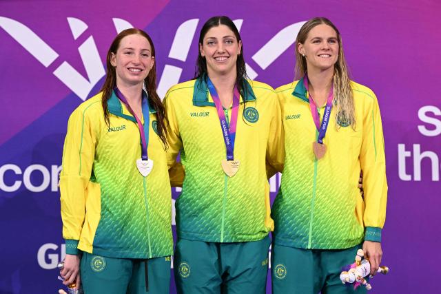 Silver medallist Australia's Mollie O'Callaghan (L), gold medallist Australia's Meg Harris (C) and bronze medallist Australia's Shayna Jack celebrate during the Women's 100m Freestyle Medal Ceremony at the swimming event at the Tollcross International Swimming Centre in Glasgow, on day four of the Commonwealth Games in Glasgow, Scotland, on July 27, 2026. (Photo by Oli SCARFF / AFP)