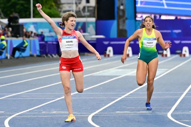 England's Sophie Hahn (L) celebrates as she crosses the finish line to win the women's 100m T38 final during the athletics event at the Scotstoun Stadium in Glasgow, on day four of the Commonwealth Games in Glasgow, Scotland, on July 27, 2026. (Photo by ANDY BUCHANAN / AFP)