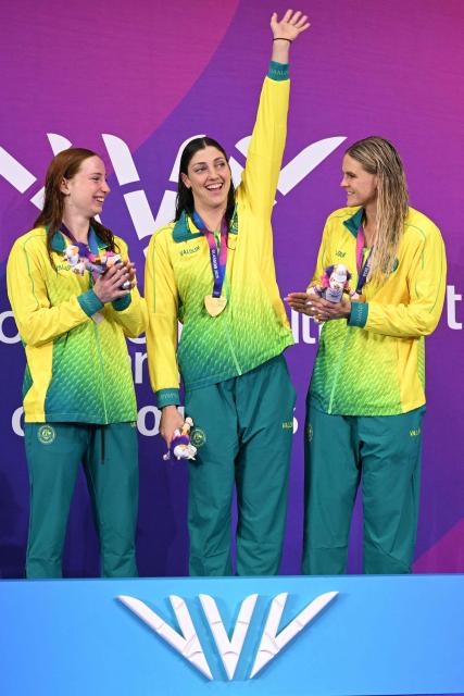 Silver medallist Australia's Mollie O'Callaghan (L), gold medallist Australia's Meg Harris (C) and bronze medallist Australia's Shayna Jack celebrate during the Women's 100m Freestyle Medal Ceremony at the swimming event at the Tollcross International Swimming Centre in Glasgow, on day four of the Commonwealth Games in Glasgow, Scotland, on July 27, 2026. (Photo by Oli SCARFF / AFP)