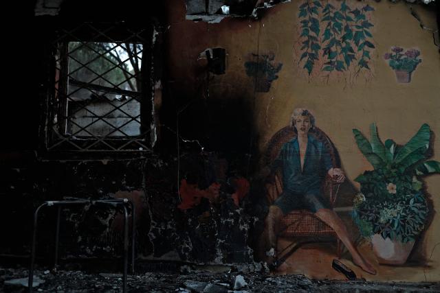 View of the burned wall of a bar at the San Juan Reservoir after a wildfire in Pelayos de la Presa, Madrid Community, Spain, in July 27, 2026. Spain faces two crucial days to bring raging wildfires under control before weather conditions worsen, authorities said on July 27, 2026, though they were making some progress and planned to start returning evacuees to certain areas. The fires in the Iberian country have affected an area of 77,000 hectares (190,000 acres) -- nearly the size of New York City -- according to the authorities. Since the start of the year, fires in Spain have ravaged 150,000 hectares and killed 13 people. (Photo by Oscar DEL POZO / AFP)