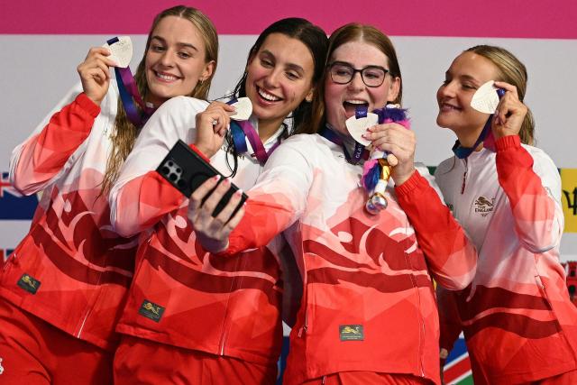 England's swimmers celebrate silver during the Women's 4 x 200m Freestyle Relay Medal Ceremony at the swimming event at the Tollcross International Swimming Centre in Glasgow, on day four of the Commonwealth Games in Glasgow, Scotland, on July 27, 2026. (Photo by Oli SCARFF / AFP)