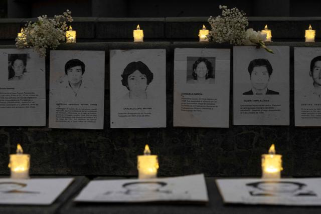 Photographs of victims and candles are displayed during a vigil by relatives of victims of crimes allegedly committed by the Peruvian state outside the Palace of Justice in Lima on July 27, 2026. (Photo by Ernesto BENAVIDES / AFP)
