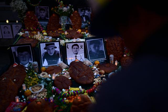 Photographs of victims are displayed alongside offerings during a vigil by relatives of victims of crimes allegedly committed by the Peruvian state outside the Palace of Justice in Lima on July 27, 2026. (Photo by Ernesto BENAVIDES / AFP)