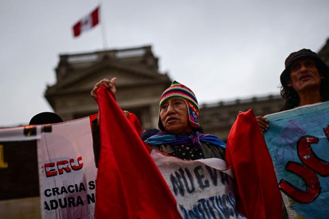 Relatives of victims of crimes allegedly committed by the Peruvian state take part in a vigil outside the Palace of Justice in Lima on July 27, 2026. (Photo by Ernesto BENAVIDES / AFP)