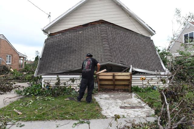 A resident cleans up debris after a tornado ripped through parts of Wisconsin in Menasha, Wisconsin, on July 27, 2026. (Photo by Octavio JONES / AFP)