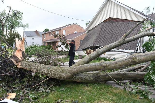 A resident cleans up debris after a tornado ripped through parts of Wisconsin in Menasha, Wisconsin, on July 27, 2026. (Photo by Octavio JONES / AFP)