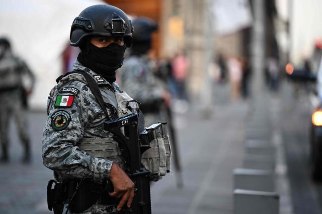 A National Guard member stands guard at the crime scene where one man was killed and two others were wounded in an armed attack at Plaza de Santo Domingo in Mexico City's historic center on July 27, 2026. A broad-daylight shooting in Mexico City left one person dead and two others injured just a few blocks from Mexico City's central Zocalo square and the presidential palace, where President Claudia Sheinbaum works and resides. (Photo by Yuri CORTEZ / AFP)