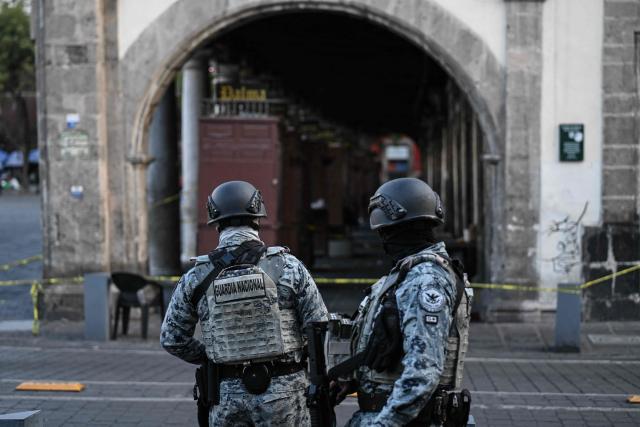 National Guard members stand guard at the crime scene where one man was killed and two others were wounded in an armed attack at Plaza de Santo Domingo in Mexico City's historic center on July 27, 2026. A broad-daylight shooting in Mexico City left one person dead and two others injured just a few blocks from Mexico City's central Zocalo square and the presidential palace, where President Claudia Sheinbaum works and resides. (Photo by Yuri CORTEZ / AFP)