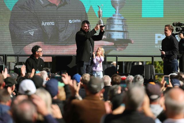 New Zealand golfer Ryan Fox (C) holds the Claret Jug trophy aloft as daughter Isobel looks up at him at a public celebration after winning the Open Chamionship golf tournament, in Auckland on July 28, 2026. Fox returned to New Zealand for a public celebration at Takutai Square in Auckland after winning the (British) Open Championship at the Royal Birkdale golf course in England on July 19. (Photo by Ben STRANG / AFP)