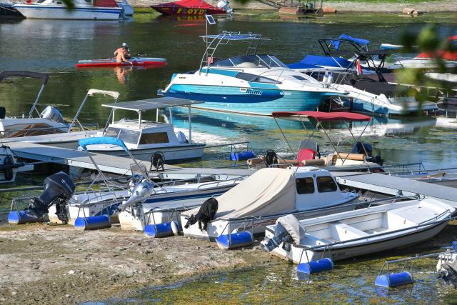 This photograph shows boats moored in a dry area along the Danube River near Novi Sad, Serbia, on July 27, 2026. Scientists say global warming is increasing droughts and causing weather emergencies to become more extreme and more frequent. Prolonged drought and hot weather across Europe have pushed water levels along the Danube river to record seasonal lows, reaching its lowest flow rate in the last 30 years. (Photo by Nenad MIHAJLOVIC / AFP)