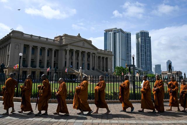 Sri Lankan Buddhist monks queue up for food along a road in Colombo on July 28, 2026. (Photo by Ishara S. KODIKARA / AFP)