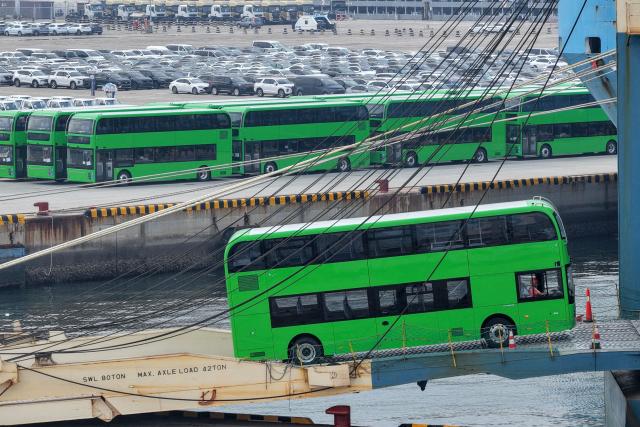 Yutong electric double-decker buses for export to the UK are driven onto a car carrier at Yantai Port in Shandong province, eastern China on July 27, 2026. (Photo by CN-STR / AFP) / China OUT