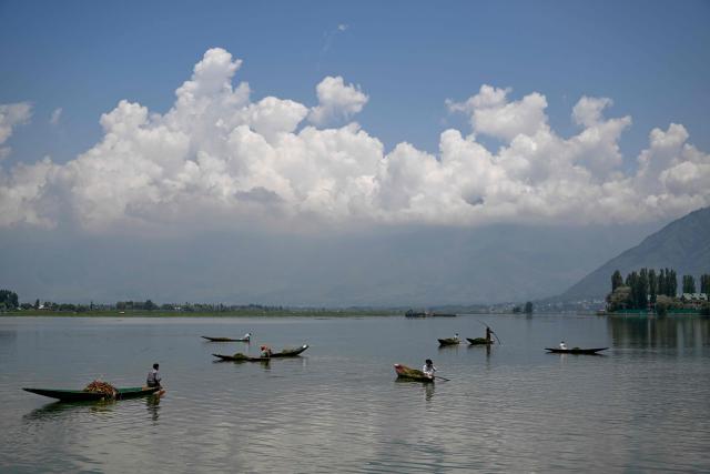 Workers from the Jammu and Kashmir Lakes and Waterways Development Authority clean the Dal Lake  in Srinagar on July 28, 2026. (Photo by TAUSEEF MUSTAFA / AFP)