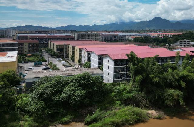 (FILES) This aerial photo taken on September 17, 2025 shows the KK Park complex, then a scam hub in Myanmar's eastern Myawaddy township, as pictured from Mae Sot district in Thailand's border province of Tak. Myanmar's military-backed parliament approved a law on July 28, 2026 authorising capital punishment for those who detain or violently coerce victims into working in online scam centres. (Photo by Lillian SUWANRUMPHA / AFP)