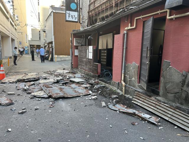 The exterior wall of a shop is seen collapsed in an earthquake, in Kumamoto City on July 28, 2026. (Photo by JIJI Press / AFP) / Japan OUT