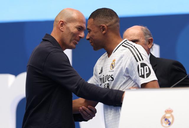 (FILES) French forward Kylian Mbappe (C) is congratulated by French former football player Zinedine Zidane (L) during a first appearance as a Real Madrid player at the Santiago Bernabeu Stadium in Madrid on July 16, 2024, after signing his new five-season contract. Zidane has been appointed as the new head coach of France national football team at the French Football Federation headquarters (FFF) in Paris on July 28, 2026. The former France playmaker, who won the 1998 World Cup and the 2000 European Championship as a player, has long been viewed as the leading candidate for the role and has been waiting for an opportunity to take charge of the national team for several years. (Photo by Pierre-Philippe MARCOU / AFP)