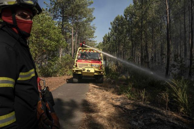 Firefighters work to extinguish flames in a forest in Claouey, near Lège-Cap-Ferret, on July 28, 2026. Over the past six days, the wildfire near Bordeaux has ravaged 42,000 hectares (103,000 acres), forced 220,000 people to flee and destroyed 240 houses. Firefighters said on July 28, 2026 the fire had not expanded overnight as they managed to tackle several flareups. (Photo by Ed JONES / AFP)