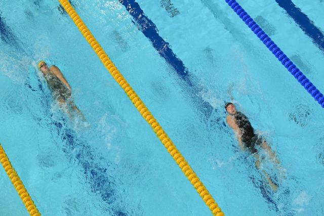 Australia's Hannah Fredericks (L) and Northern Ireland's Lottie Cullen take part the Mixed 4 x 100m Medley Relay - Heats swimming event at the Tollcross International Swimming Centre in Glasgow, on day five of the Commonwealth Games in Glasgow, Scotland, on July 28, 2026. (Photo by Oli SCARFF / AFP)