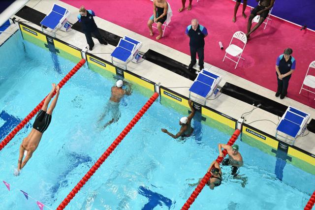 Fiji's David Young (L) dives into the pool for the last leg of the Mixed 4 x 100m Medley Relay - Heats swimming event at the Tollcross International Swimming Centre in Glasgow, on day five of the Commonwealth Games in Glasgow, Scotland, on July 28, 2026. (Photo by Oli SCARFF / AFP)