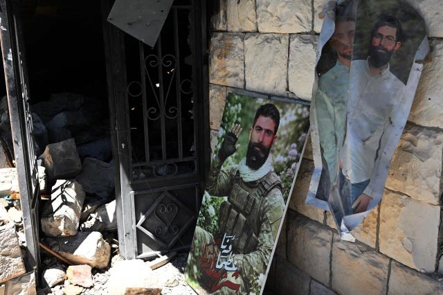 The portrait of a Hezbollah fighter killed during the conflict sits at the entrance of his family's destroyed home in Zawtar al-Gharbiya on July 28, 2026, as residents return to inspect their homes after the Lebanese army deployed to the southern village last week as part of a framework deal reached with Israel. Under a US-sponsored agreement signed last month, Lebanon's army is to disarm Hezbollah and the Israeli military is to withdraw from "pilot zones" where Lebanese forces will subsequently deploy. The deal came more than three months after Hezbollah drew Lebanon into the Middle East with rocket fire at Israel in support of Tehran, triggering major Israeli airstrikes and a ground invasion that Lebanese authorities say have killed more than 4,300 people. (Photo by Joseph EID / AFP) / 