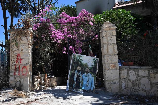 A portrait of residents killed during the conflict sits at the entrance of their home in Zawtar al-Gharbiya on July 28, 2026, as residents return to inspect their homes after the Lebanese army deployed to the southern village last week as part of a framework deal reached with Israel. Under a US-sponsored agreement signed last month, Lebanon's army is to disarm Hezbollah and the Israeli military is to withdraw from "pilot zones" where Lebanese forces will subsequently deploy. The deal came more than three months after Hezbollah drew Lebanon into the Middle East with rocket fire at Israel in support of Tehran, triggering major Israeli airstrikes and a ground invasion that Lebanese authorities say have killed more than 4,300 people. (Photo by Joseph EID / AFP) / 