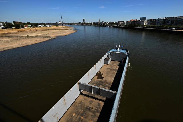 An empty vessel drives along the partially dried-up river bed of the Rhine in Duesseldorf, western Germany, on July 28, 2026, following exceptionally hot weather. (Photo by Ina FASSBENDER / AFP)