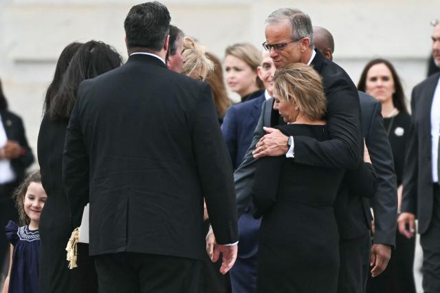 US Senate Majority Leader John Thune, Republican from South Dakota, embraces Senator Darline Graham, Republican from South Carolina, following a Congressional tribute to late US Senator Lindsey Graham at the US Capitol in Washington, DC, on July 28, 2026. Graham, a South Carolina Republican and key Trump ally who was elected to the Senate four times, died at age 71 on July 11. (Photo by Kent NISHIMURA / AFP)
