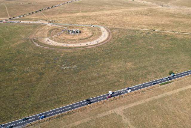 This aerial image shows the scorched grass surrounding the area at Stonehenge near Amesbury, Wiltshire in southern England on July 28, 2026. Temperatures were forecast this week to rise back into the 30s for parts of England, following three heatwaves so far over the summer. (Photo by JUSTIN TALLIS / AFP)