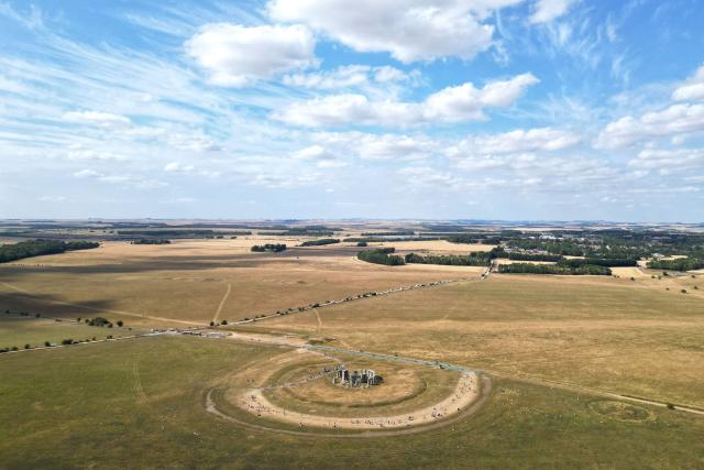 This aerial image shows the scorched grass surrounding the area at Stonehenge near Amesbury, Wiltshire in southern England on July 28, 2026. Temperatures were forecast this week to rise back into the 30s for parts of England, following three heatwaves so far over the summer. (Photo by JUSTIN TALLIS / AFP)