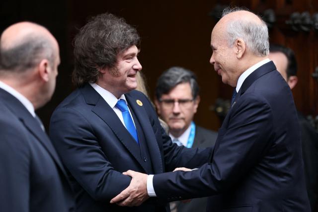 Argentina's President Javier Milei (L) shakes hands with Peru's Deputy Foreign Minister Eric Anderson Machado at the Foreign Affairs Ministry after meeting Peru's President-elect Keiko Fujimori ahead of her inauguration in Lima, July 28, 2026. Fujimori will take office on July 28, 2026, vowing to tackle the wave of crime sweeping the Andean nation. Fujimori won the June 7 presidential runoff by fewer than 50,000 votes, after losing the past three runoffs. (Photo by Connie FRANCE / AFP)
