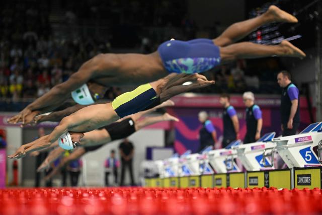 Singapores Tzen Wei Teong ((C) dives into the pool in the Men's 50m Butterfly Semi-Final at the swimming event at the Tollcross International Swimming Centre in Glasgow, on day five of the Commonwealth Games in Glasgow, Scotland, on July 28, 2026. (Photo by Oli SCARFF / AFP)