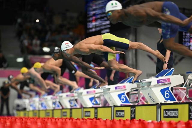 Singapores Tzen Wei Teong (2R) dives into the pool in the Men's 50m Butterfly Semi-Final at the swimming event at the Tollcross International Swimming Centre in Glasgow, on day five of the Commonwealth Games in Glasgow, Scotland, on July 28, 2026. (Photo by Oli SCARFF / AFP)