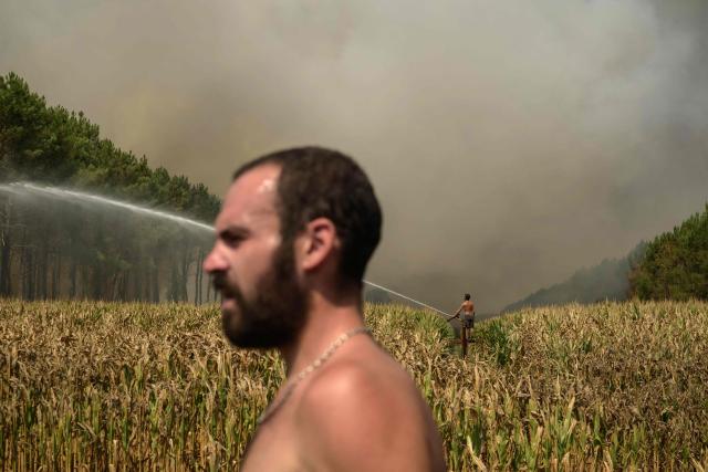 TOPSHOT - Volunteers help firefighters to tackle a wildfire near Lanton, east of the Arcachon Bay, west of Bordeaux on July 29, 2026, during wildfires in the Gironde region, southwestern France. The Gironde and neighbouring Landes departments are under an orange-level warning from midday on July 29, with inland temperatures of 41C forecast and 38C on the coast. (Photo by Ed JONES / AFP)