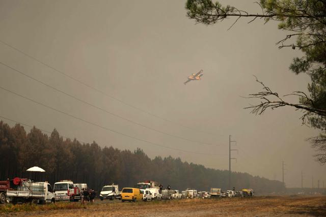 A Canadair CL-415 aircraft flies over a wildfire near Lanton, east of the Arcachon Bay, west of Bordeaux on July 29, 2026, during wildfires in the Gironde region, southwestern France. The Gironde and neighbouring Landes departments are under an orange-level warning from midday on July 29, with inland temperatures of 41C forecast and 38C on the coast. (Photo by Ed JONES / AFP)