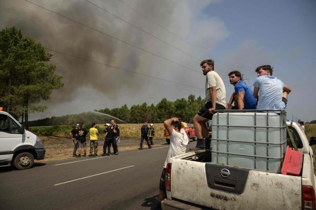 Firefighters and volunteers tackle a wildfire near Lanton, east of the Arcachon Bay, west of Bordeaux on July 29, 2026, during wildfires in the Gironde region, southwestern France. The Gironde and neighbouring Landes departments are under an orange-level warning from midday on July 29, with inland temperatures of 41C forecast and 38C on the coast. (Photo by Ed JONES / AFP)