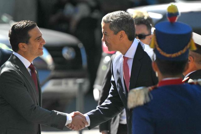 Paraguay's President Santiago Pena (R) is welcomed by Ecuador's Foreign Affairs Minister Roberto Kury as he arrives for a wreath-laying ceremony at the Ecuadorean Independence Heros monument in downtown Quito on July 29, 2026. (Photo by Rodrigo BUENDIA / AFP)