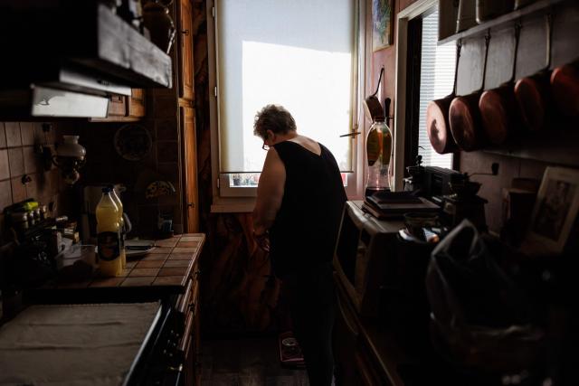 Chantal Molignier, 76, lowers the window blind in her kitchen at Place des Fêtes during a hot summer day in Paris on July 29, 2026. The retired couple say their home turns into a "thermal kettle" during heatwaves, becoming unbearably hot. Western Europe this year experienced its hottest June on record as a searing heatwave swept across a continent facing increasingly frequent and intense heat extremes, the EU's climate monitor said on July 9, 2026. (Photo by Simon WOHLFAHRT / AFP)