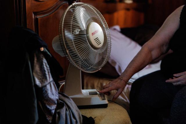 Chantal Molignier, 76, turns on the fan in a bedroom of her apartment at Place des Fêtes during a hot summer day in Paris on July 29, 2026. The retired couple say their home turns into a "thermal kettle" during heatwaves, becoming unbearably hot. Western Europe this year experienced its hottest June on record as a searing heatwave swept across a continent facing increasingly frequent and intense heat extremes, the EU's climate monitor said on July 9, 2026. (Photo by Simon WOHLFAHRT / AFP)