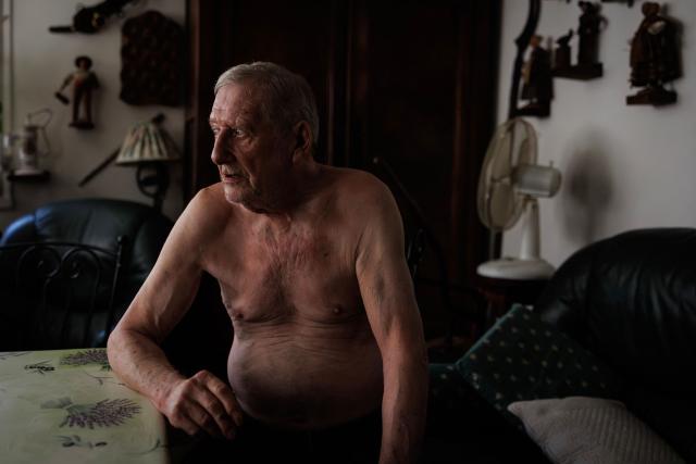 Daniel Molignier, 80, smokes a cigar next to fans in his apartment at Place des Fêtes during a hot summer day in Paris on July 29, 2026. The retired couple say their home turns into a "thermal kettle" during heatwaves, becoming unbearably hot. Western Europe this year experienced its hottest June on record as a searing heatwave swept across a continent facing increasingly frequent and intense heat extremes, the EU's climate monitor said on July 9, 2026. (Photo by Simon WOHLFAHRT / AFP)
