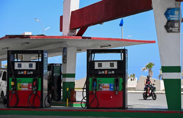 An man rides past an empty gas station in Havana on July 29, 2026. Cuba on July 28, 2026, moved to open several key crisis-ravaged sectors of its state-run economy to private firms, as the communist government tries to ease acute shortages resulting from a US energy blockade. (Photo by YAMIL LAGE / AFP)