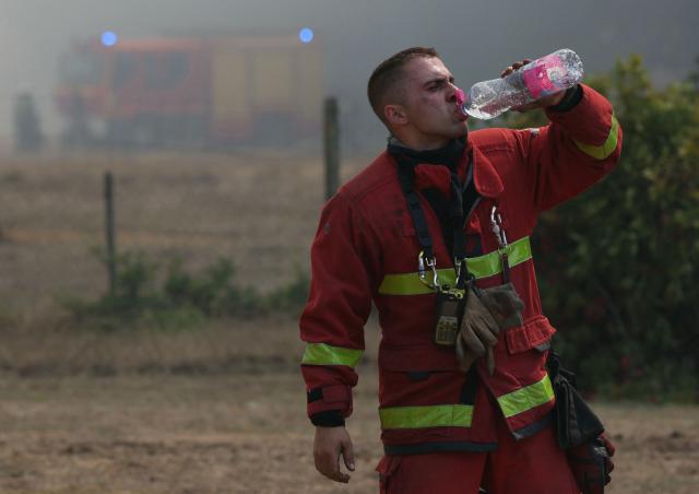 A firefighter drinks from a water bottle amid operations against a wildfire near Lanton, southwestern France, on July 29, 2026. The return of intense heat on July 29, 2026, and sea winds are fanning the megafire in Gironde, with new flare-ups in places after a second, calmer night that had made it possible to “stabilize” the blaze. Forests catch fire all the more easily because the vegetation and soil have been extremely dry for months, a drought worsened by climate change and the recent exceptional heatwaves. (Photo by Alain JOCARD / AFP)