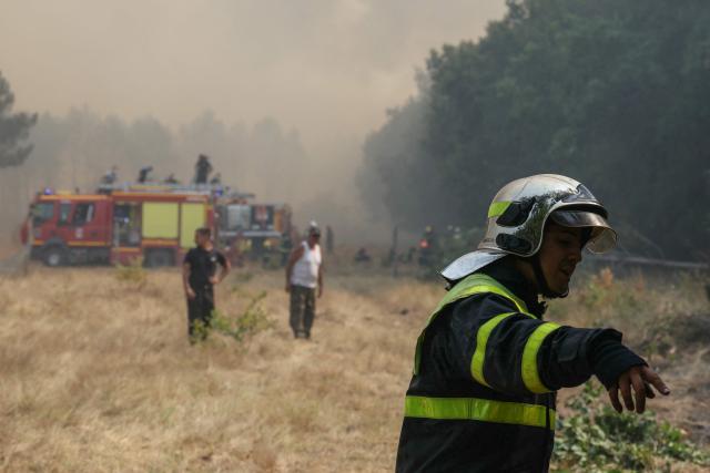 A firefighter gestures amid operations against a wildfire near Lanton, southwestern France, on July 29, 2026. The return of intense heat on July 29, 2026, and sea winds are fanning the megafire in Gironde, with new flare-ups in places after a second, calmer night that had made it possible to “stabilize” the blaze. Forests catch fire all the more easily because the vegetation and soil have been extremely dry for months, a drought worsened by climate change and the recent exceptional heatwaves. (Photo by Alain JOCARD / AFP)