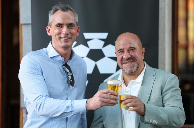 Pro League CEO Lorin Parys and DAZN Belgium CEO Massimo D'Amario pose with a beer during a press meeting of the Pro League in preparation of the 2026-2027 football season, in Machelen on July 2026. (Photo by VIRGINIE LEFOUR / Belga / AFP) / Belgium OUT