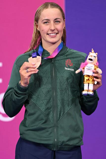 Bronze medallist Northern Ireland's Ellie McCartney celebrates during the Women's 200m Breaststroke Medal Ceremony at the swimming event at the Tollcross International Swimming Centre in Glasgow, on day six of the Commonwealth Games in Glasgow, Scotland, on July 29, 2026. (Photo by Oli SCARFF / AFP)