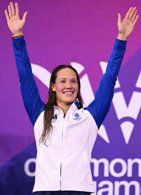 Gold medallist Scotland's Angharad Evans celebrates during the Women's 200m Breaststroke Medal Ceremony at the swimming event at the Tollcross International Swimming Centre in Glasgow, on day six of the Commonwealth Games in Glasgow, Scotland, on July 29, 2026. (Photo by Oli SCARFF / AFP)