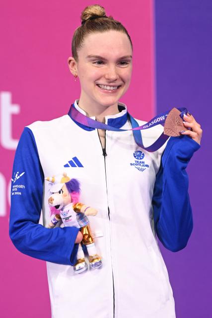 Bronze medallist Scotland's Toni Shaw celebrate during the Women's S9 100m Freestyle Medal Ceremony at the swimming event at the Tollcross International Swimming Centre in Glasgow, on day six of the Commonwealth Games in Glasgow, Scotland, on July 29, 2026. (Photo by Oli SCARFF / AFP)