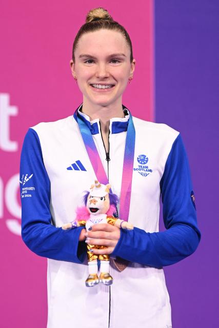 Bronze medallist Scotland's Toni Shaw celebrate during the Women's S9 100m Freestyle Medal Ceremony at the swimming event at the Tollcross International Swimming Centre in Glasgow, on day six of the Commonwealth Games in Glasgow, Scotland, on July 29, 2026. (Photo by Oli SCARFF / AFP)