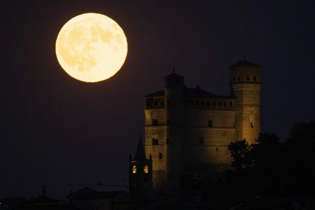 The "Elk Moon" rises behind the castle of the village of Serralunga d'Alba, Langhe Countryside, Northwestern Italy, on July 29, 2026. (Photo by Marco Bertorello / AFP)