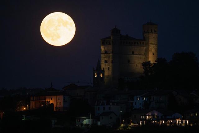 The "Elk Moon" rises behind the castle of the village of Serralunga d'Alba, Langhe Countryside, Northwestern Italy, on July 29, 2026. (Photo by Marco Bertorello / AFP)