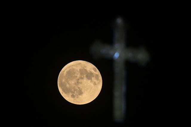 The full moon, known as the Buck Moon, rises over the Church of St. John the Baptist in Skopje on July 29, 2026. (Photo by Robert ATANASOVSKI / AFP)